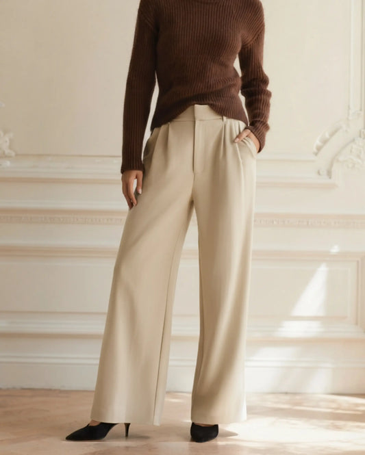 Women's beige high-waist tailored wide-leg trousers with front pleats, styled with brown strappy sandals