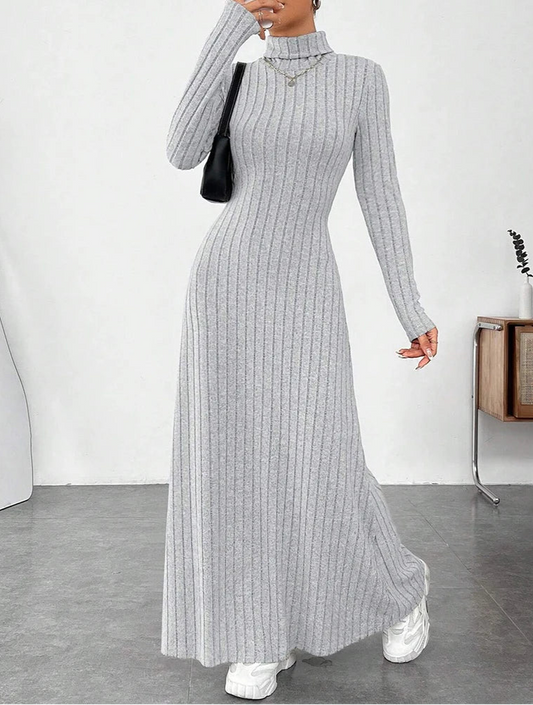 Woman wearing Vohran ribbed high-neck knit maxi dress with long sleeves and high neckline Vohran UK.