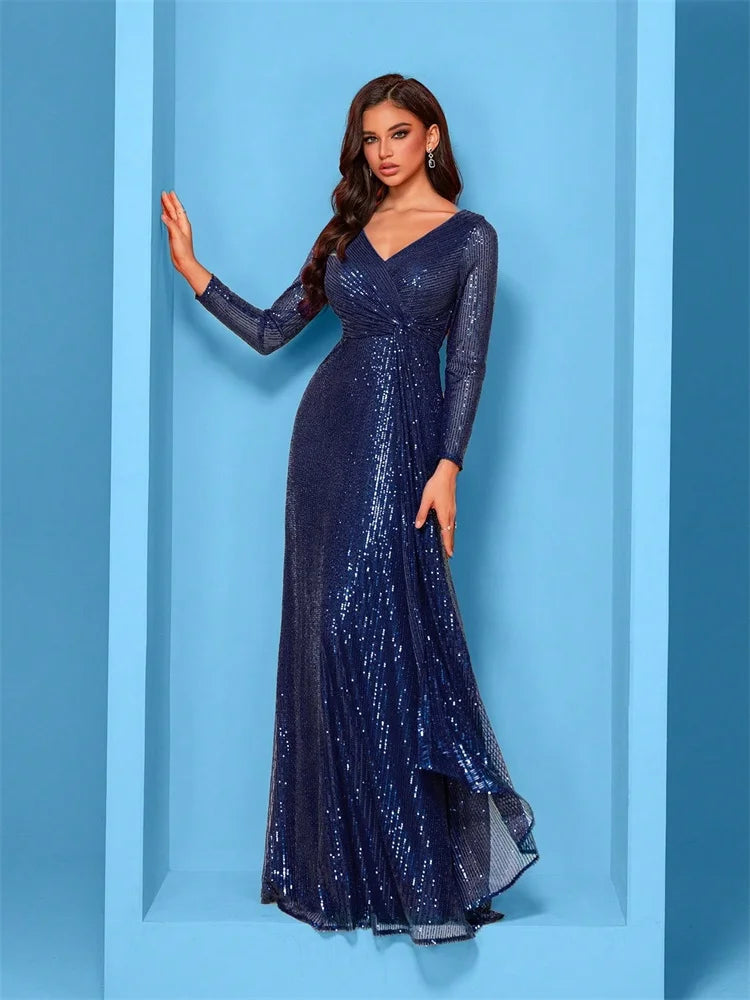 Woman wearing a sapphire blue long-sleeve sequin evening gown with a draped waist in a modern blue studio setting Vohran UK.